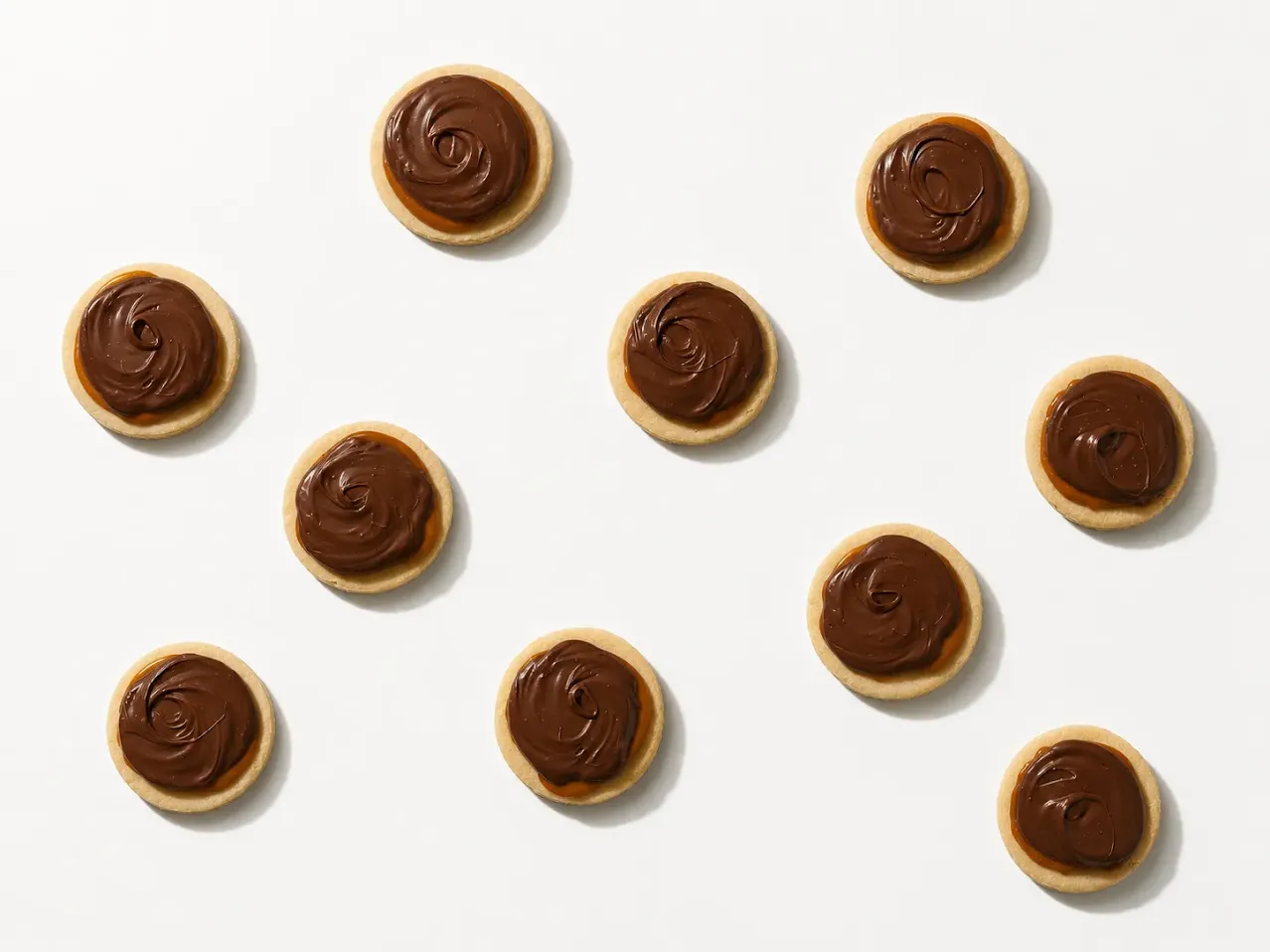Small chocolate-finished bakes arranged on a white background.